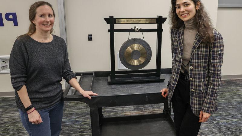 Anna and Nora standing with a gong